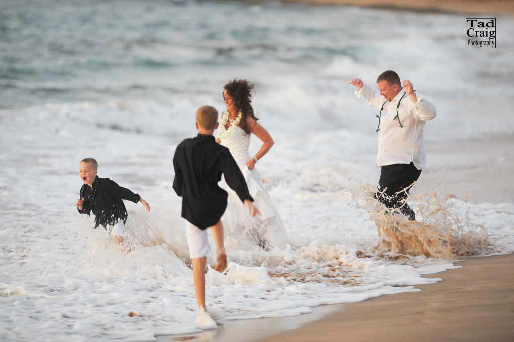 Family playing in ocean dressed