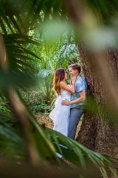 Good looking couple kissing in a Tropical Maui Forset taken by Tad Craig Photography